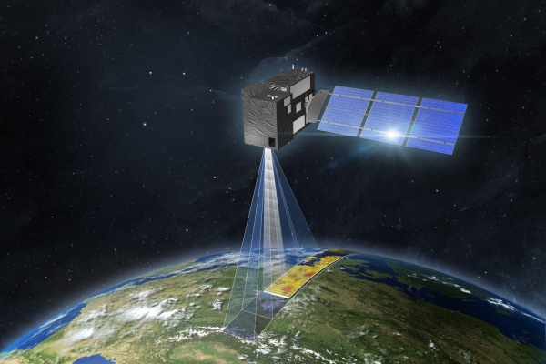 OBSERVER: Advancing Earth Observation with the Copernicus Sentinel Expansion Missions The image is an artist’s impression of a CO2M satellite in space. The satellite has a rectangular body with solar panels extending from one side. It is positioned above Earth, with a visible beam projecting downward, indicating the satellite's monitoring capabilities. The Earth's surface below shows a detailed section of land with varying colours, likely representing data collected by the satellite. The background features the dark expanse of space dotted with stars. This satellite image is credited to OHB