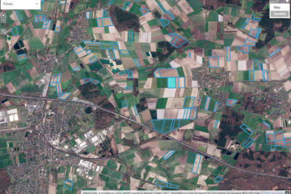 Observer: Revealing hidden land patterns with AI and Copernicus Aerial view of a colorful patchwork of agricultural fields marked with data overlays, alongside urban areas and roads.